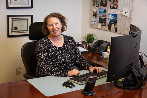 woman smiling behind work desk