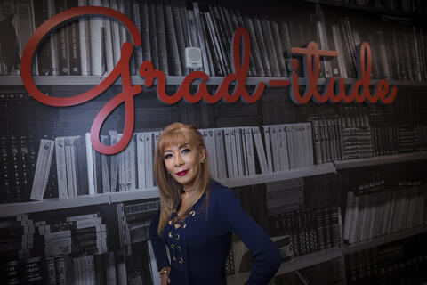 woman posing in front of "Grad-titude" signage