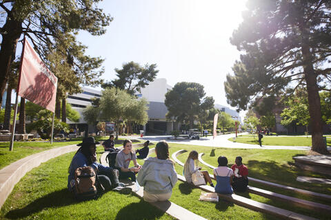 Students outdoors socializing, studying, reading, and interacting