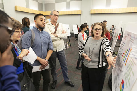 group of people watching woman present poster