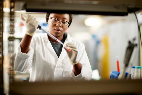 female student in lab working with science equipment