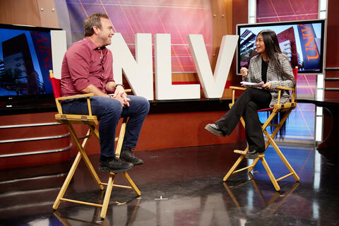 female student interviewing man on tv set