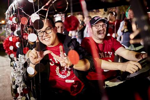 People driving around in golf cart during homecoming parade