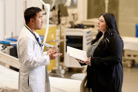 woman in professional work attire talking to a doctor in a hospital room