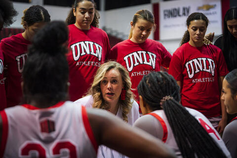 coach with players huddled around her