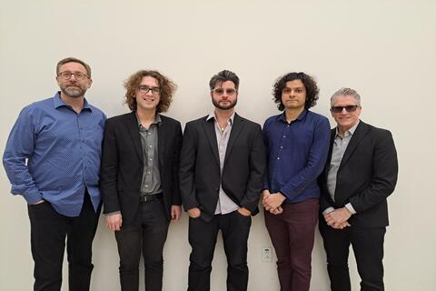 group of five man standing in front of white background