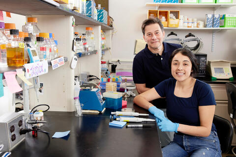 female student and male faculty member posing in science lab