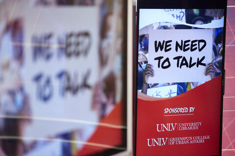 Screen graphic of person holding sign that reads we need to talk