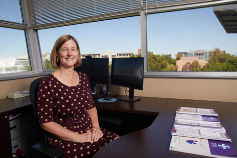 woman sitting at desk with windows in background