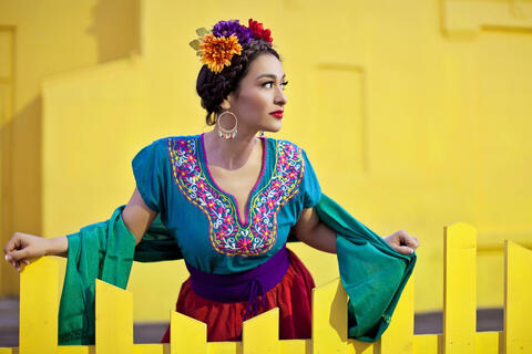 woman in colorful outfit in front of yellow background