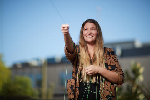 woman outside and pulling on a piece of string