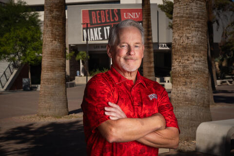 man in red shirt with arms crossed over chest