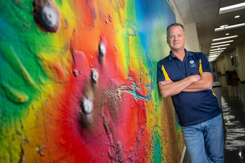 man leaning on wall painted with bright colors