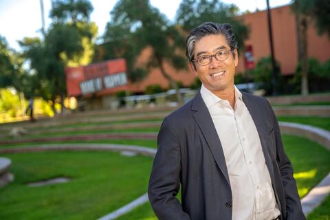 man with glasses standing outside in suit jacket