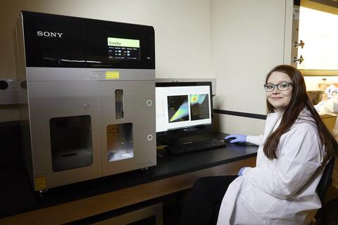 woman in white labcoat using computer