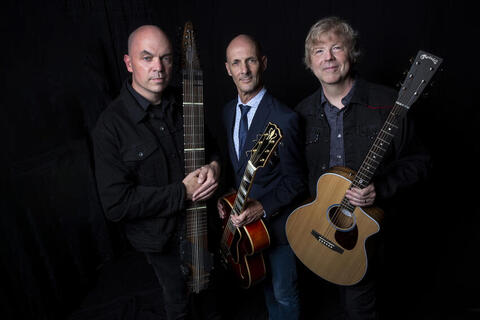 three men holding different instruments