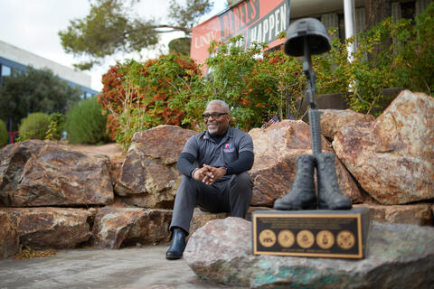 man poses near memorial structure dedicated to veterans