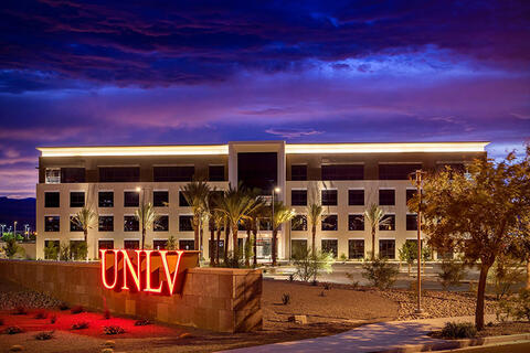 External view at night of the Howard Hughes building with the UNLV signage off to the left