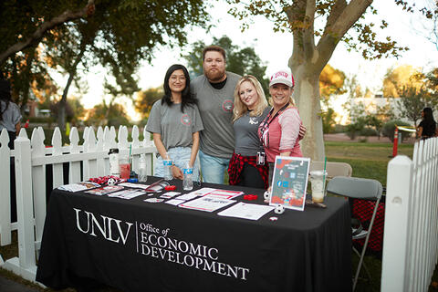Group of people standing behind a table for the office of economic development