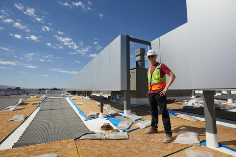 young man in safety vest posing in on construction site
