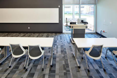 view of a conference room with two long tables and three chairs