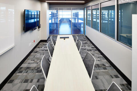 one long table in the center with gray chairs