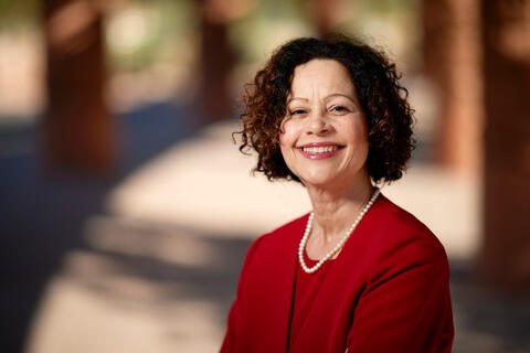 cropped photo of woman in red blazer smiling
