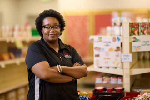 woman with arms crossed standing inside food pantry
