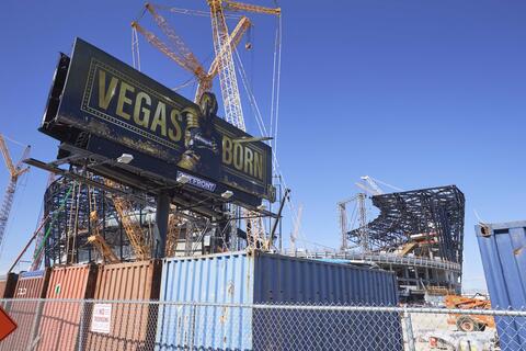 construction activity on Allegiant Stadium with Golden Knights billboard in foreground