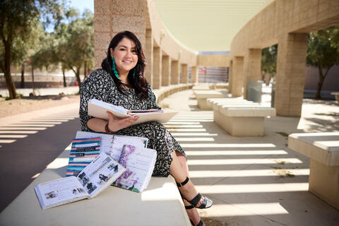 woman on bench sitting next to binders
