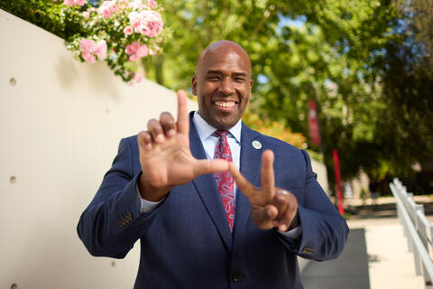man holding up hands to show LV for UNLV