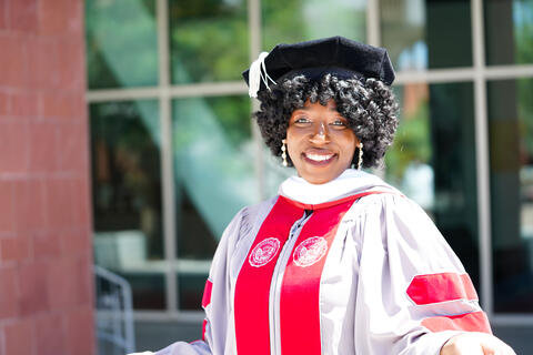 Doctoral graduate wearing a graduation gown