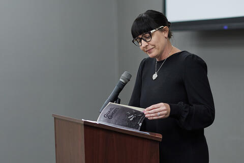 Person reading a book on a podium