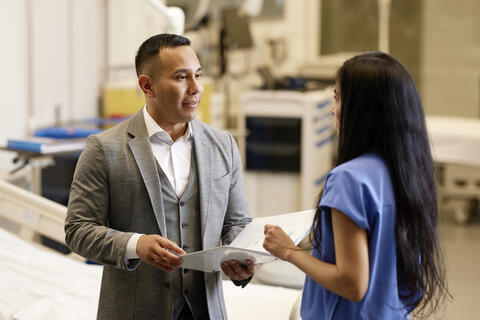 two people talking in front of a hospital lobby
