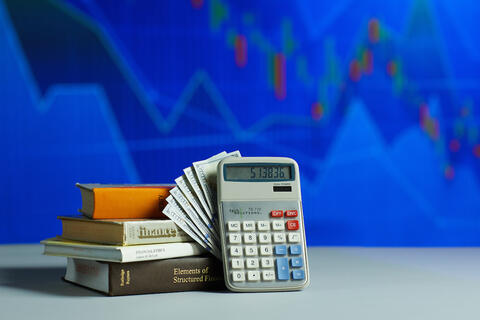 Calculator resting on a stack of financial education books