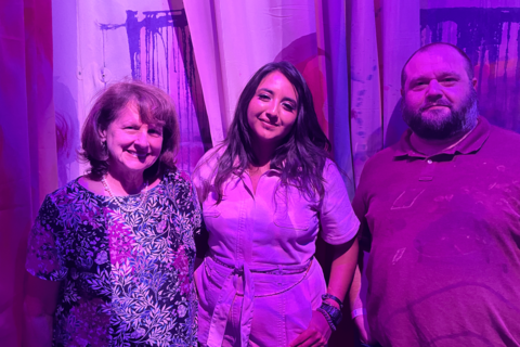 purple light filter covering three standing individuals