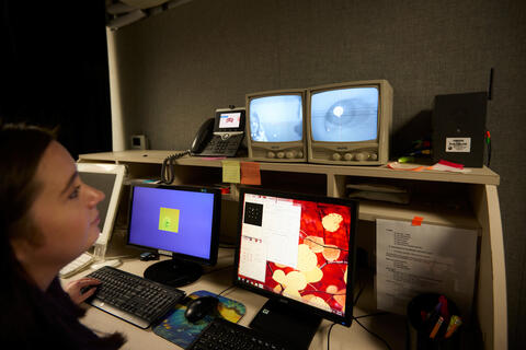 A psychology lab researcher tracks the eye movements of a toddler through the eye-tracker.