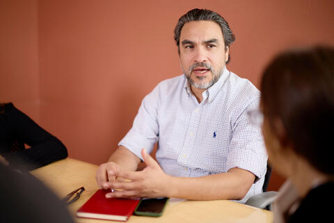 Person sitting on a table with a red notebook