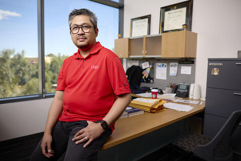 man poses in his office