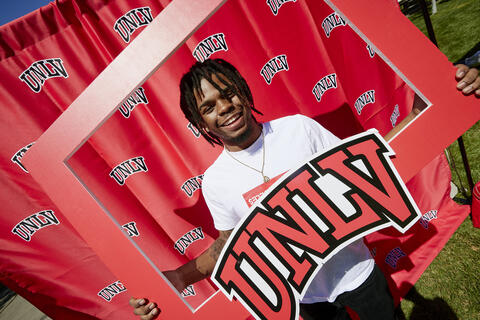 Person holding a sign with the UNLV logo
