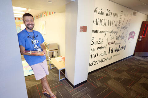 An RA poses in front of the World Languages themed residence hall.