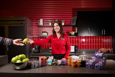 Kennedy Springer stands in front of a counter of healthy foods
