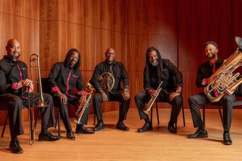 5 men holding different brass wind instruments