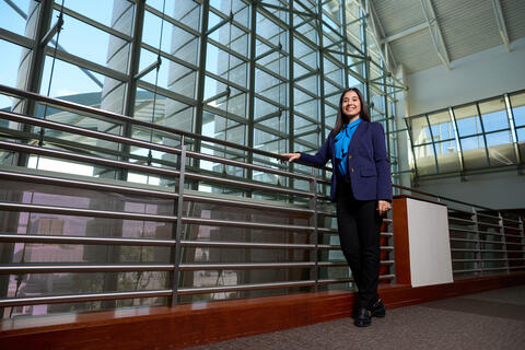 Clariana Vitoria Ramos de Oliveira stands near wall of windows