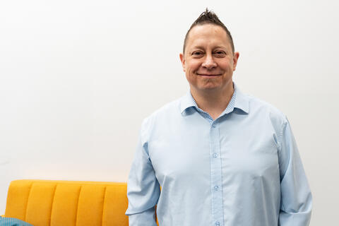 Dustin Hines standing in front of white wall