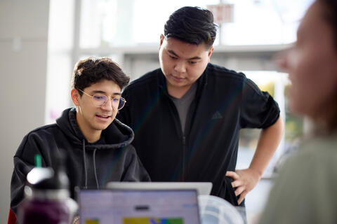 two people looking in a laptop screen