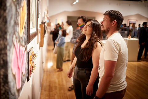 Two people looking at artwork on the wall