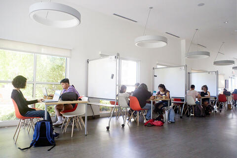 A study hall with people sitting down at tables