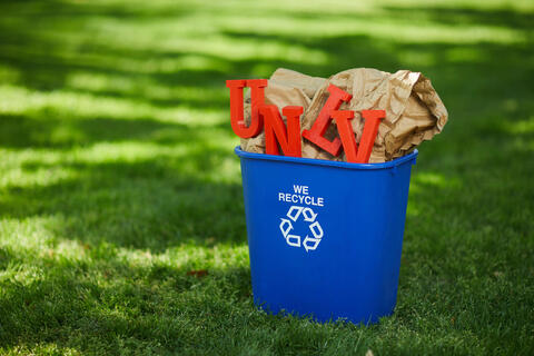 red UNLV letters set on small recycling bin