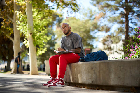 Kinesiology student Zachary Coleman studies outside.